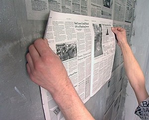 Удаление старой краски с бетонной стены с применение газет и обойного клея